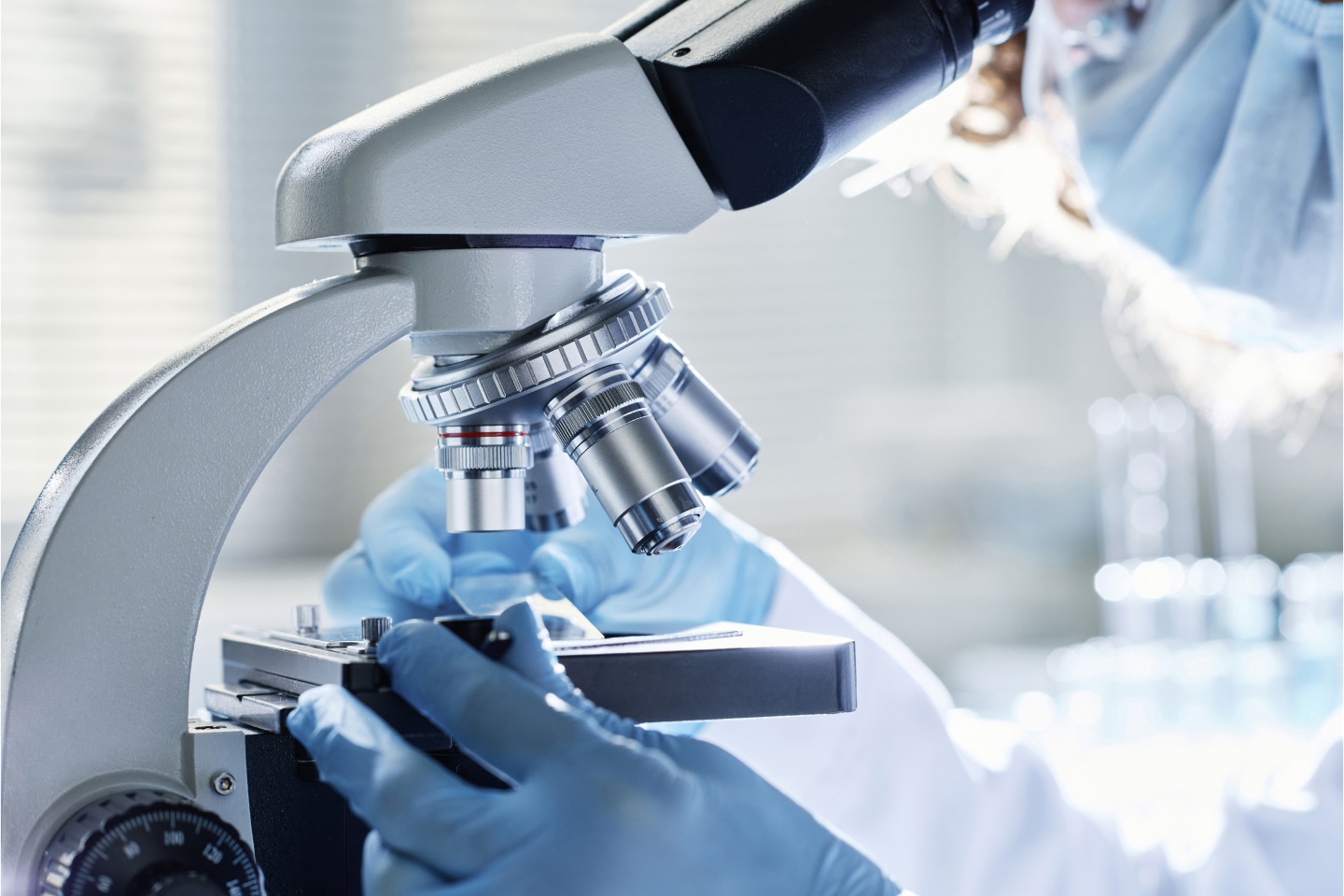 Person using a microscope to view samples in a lab