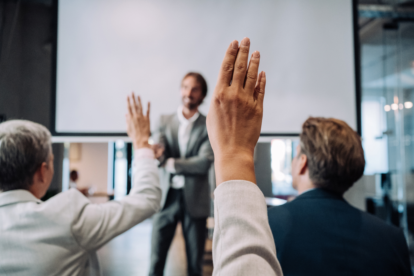 Shareholders raising their hands in a crowded room trying to make a positive change