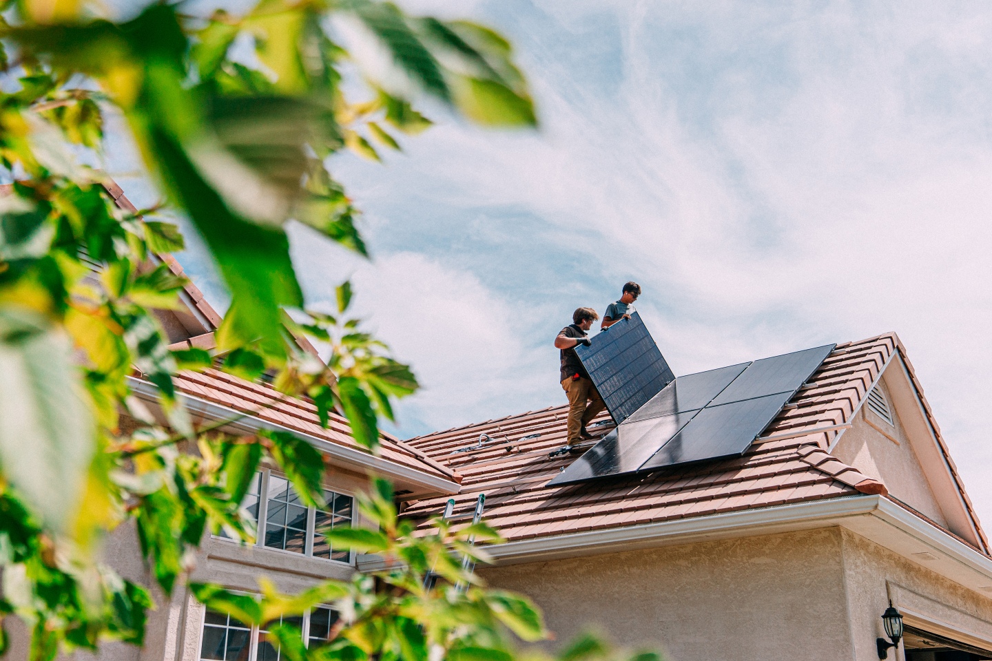 Men on roof installing solar panel