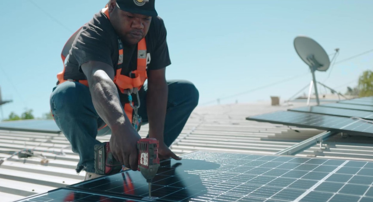 Indigenous Australian man installing solar panels for Original Power led project