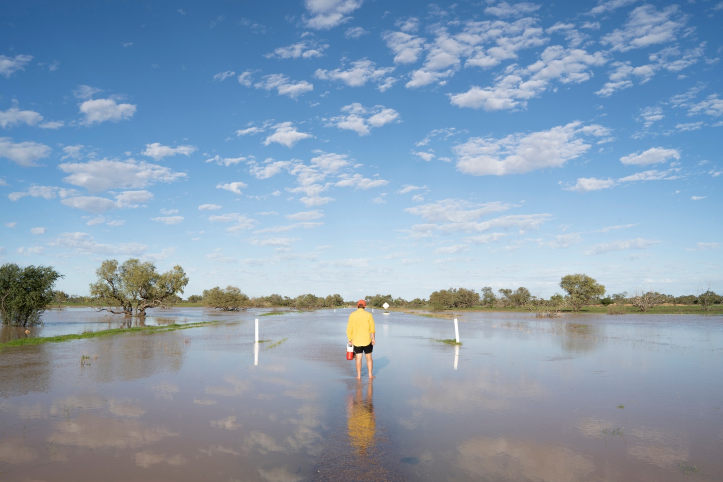 Person walking through flood waters in rural Australia