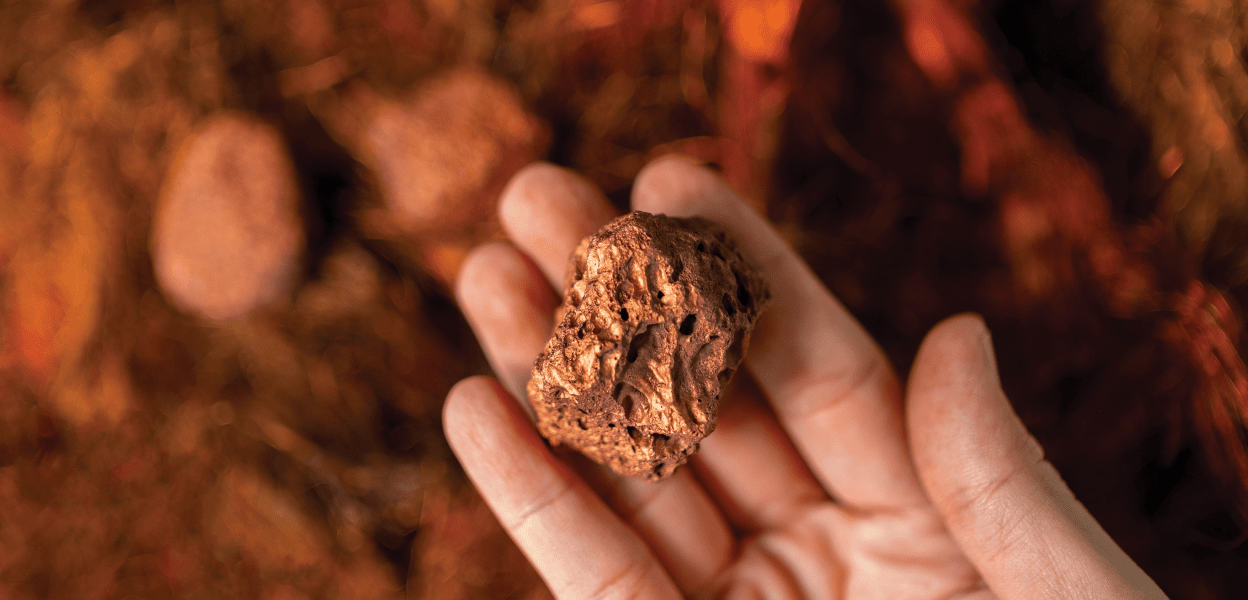 Hand holding nugget of copper