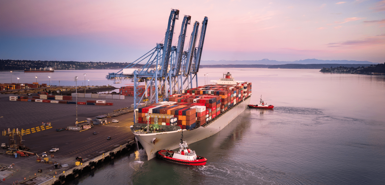 Container ship at port being loaded with shipping crates