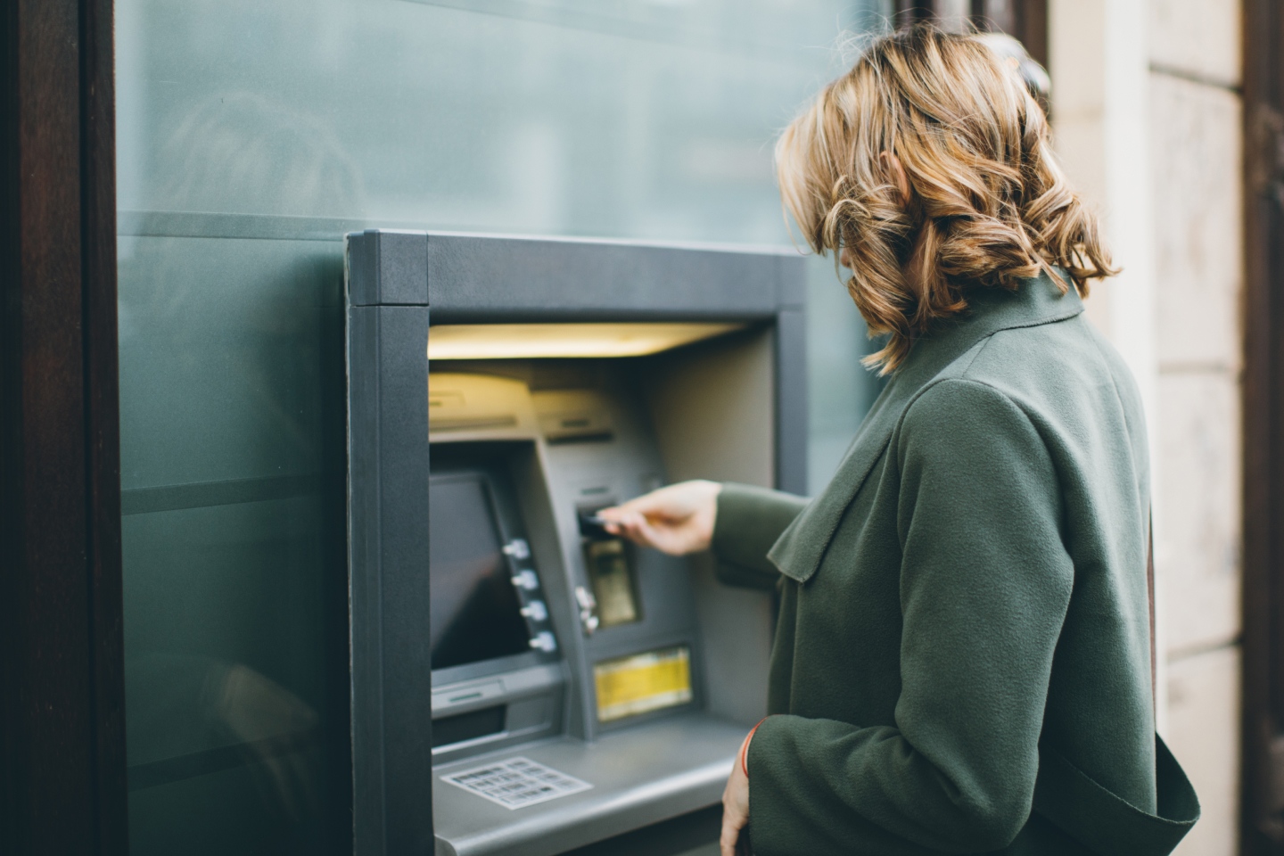 Woman withdrawing money at an ATM, representing the Commonwealth Bank of Australia