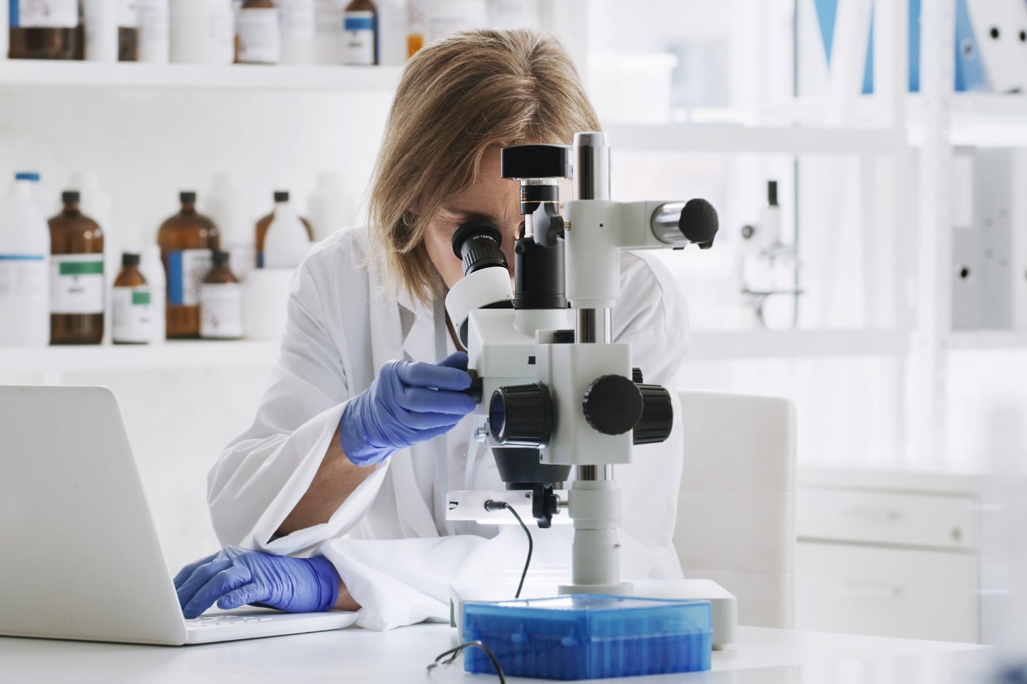 Scientist in a lab looking through a microscope