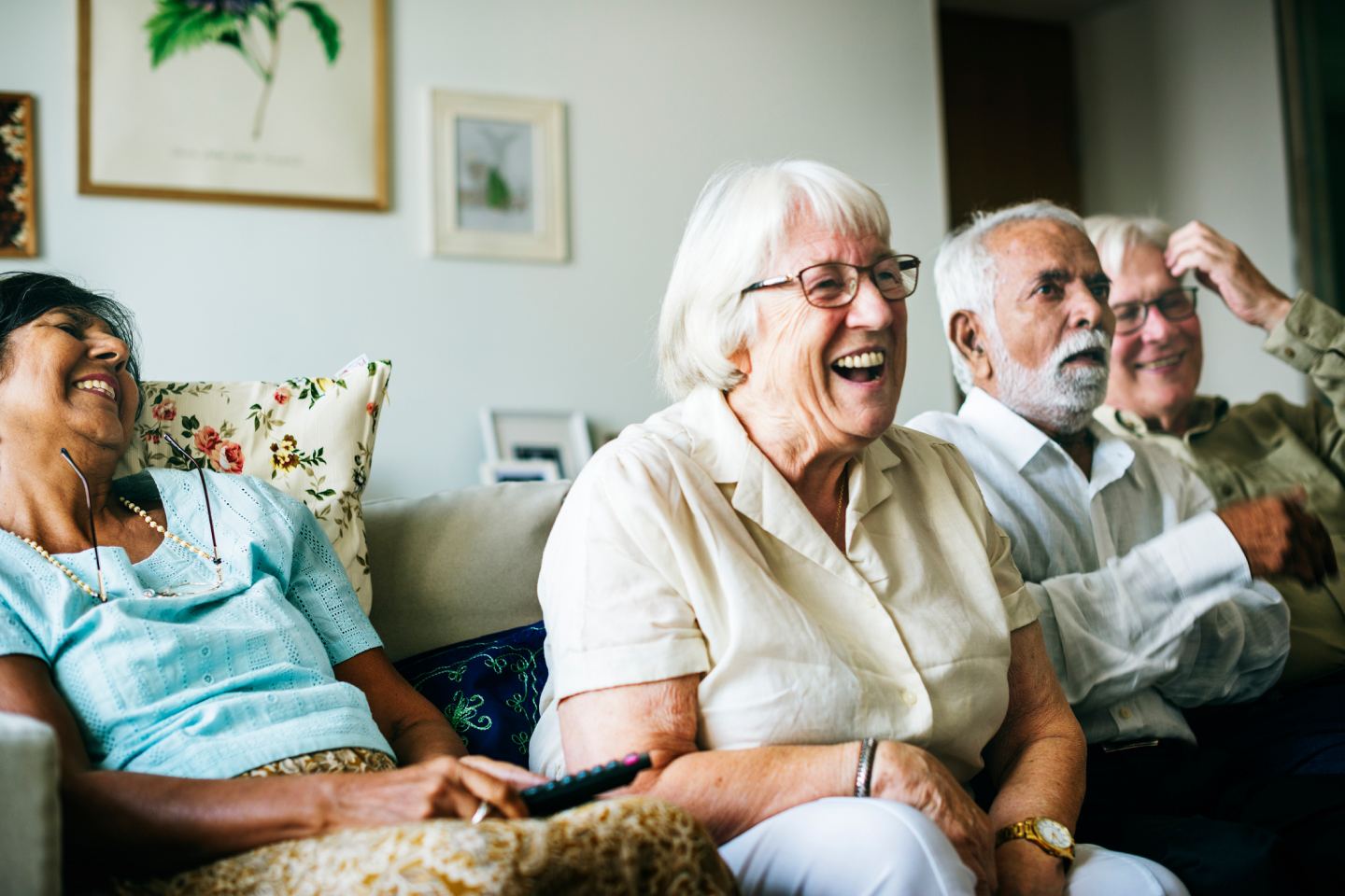 Group of retired people laughing on a couch