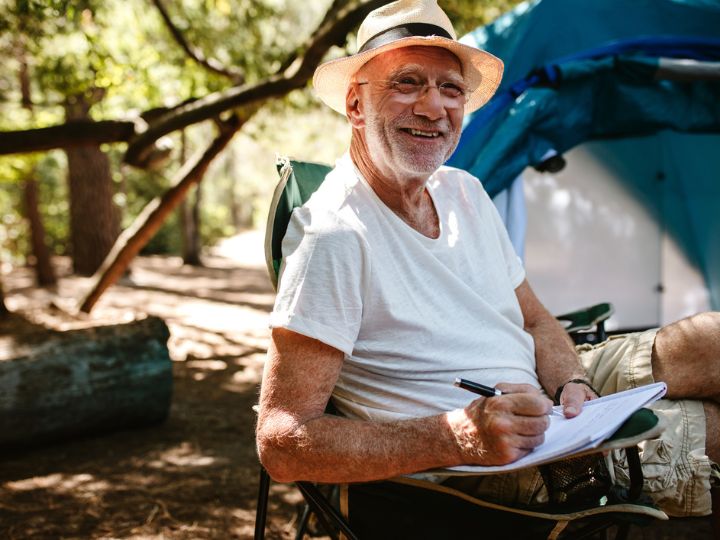 Senior man on camping trip working out his retirement income