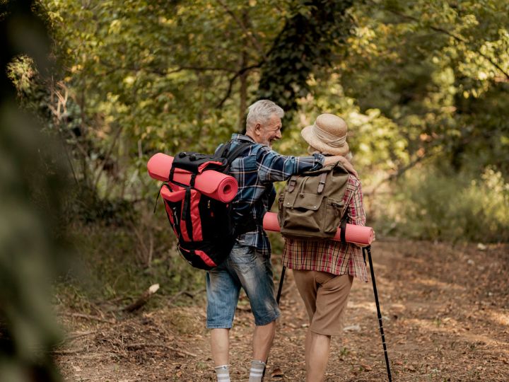 Retired couple on a bush walk with their camping gear