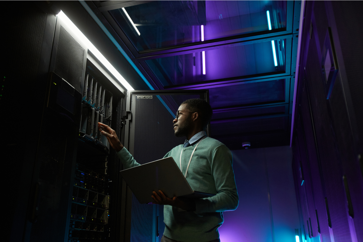 Man working on a breaker in a room full of technology