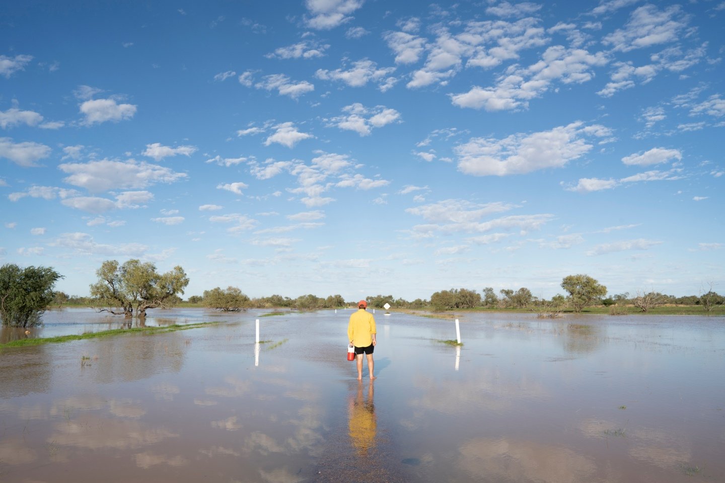 Person walking through flood waters in rural Australia