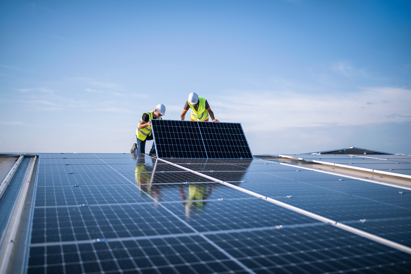 People installing solar panels for a gradual switch to green energy alternatives